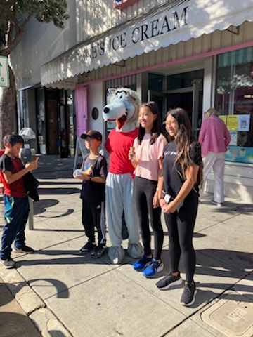 Wolfie posing with Argonne students in front of Joe's Ice Cream.